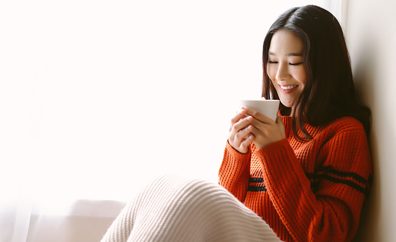 温かい飲み物を飲む女性